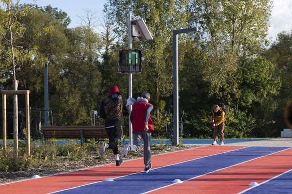 Dos corredores en la pista de atletismo en Saint-Dizier, con un radar pedagógico EVOLIS Vision mostrando une velocidad de 17km/h